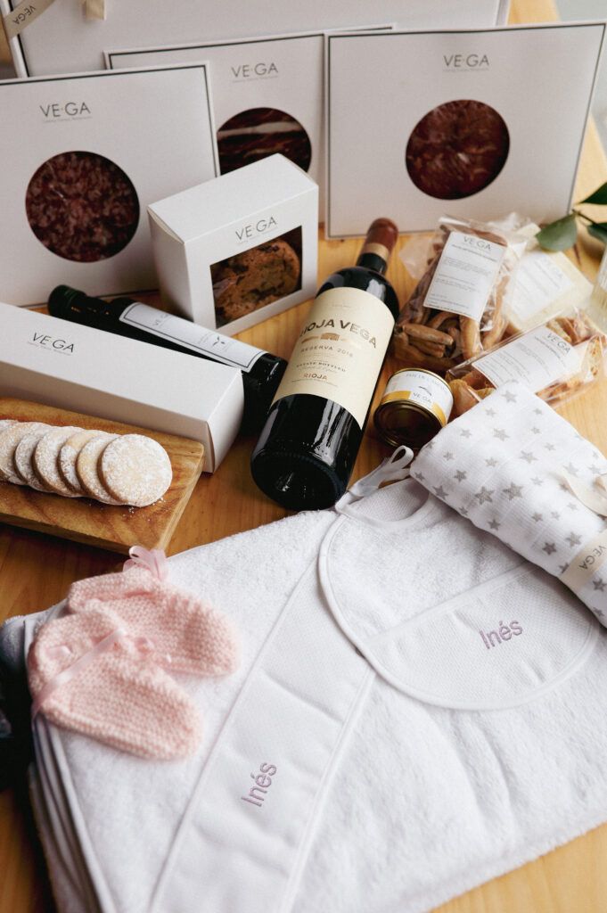 Caja gourmet recién mamá con toalla y babero bordado, patucos, muselina y champagne